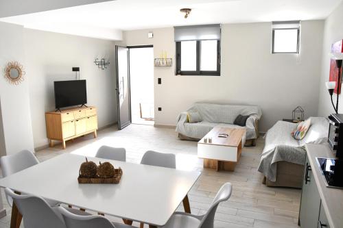 a living room with a white table and chairs at Polles Εlies Cozy Αpartment in Aegina Town