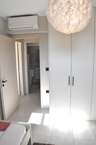a room with a hallway with a large light fixture at Polles Εlies Cozy Αpartment in Aegina Town
