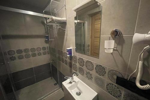 y baño con lavabo y espejo. en Osmanlı Paşa Otel- Konaklama en Samsun