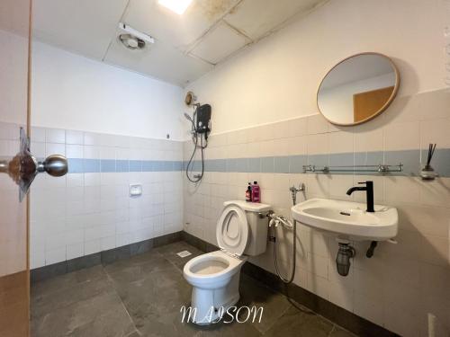 a bathroom with a toilet and a sink and a mirror at BayView Suites Port Dickson By MAISON in Port Dickson