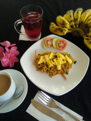 a table with two plates of food and a cup of tea at Kuta Garden in Kuta Lombok