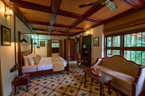 a bedroom with a bed and a couch in a room at Malabar Kovilakam in Malappuram