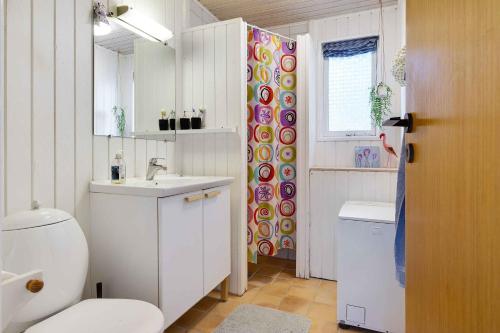 a white bathroom with a toilet and a sink at Nice Holiday Home in Humble