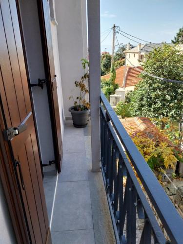 an open door to a balcony with a plant at Marousos Central Guesthouse in Portariá