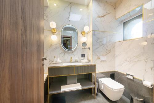 La salle de bains est pourvue d'un lavabo, de toilettes et d'un miroir. dans l'établissement Yasu Luxury Rooms, à Bucarest