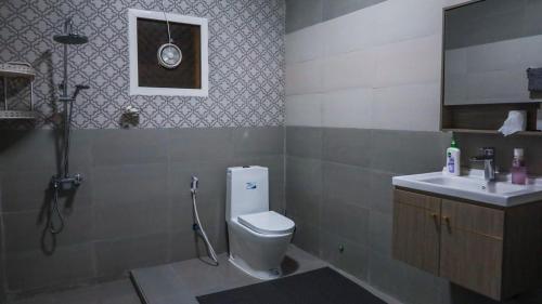 a bathroom with a toilet and a sink at Al Dhabi Farm with Meeting Hall in Şufayrī