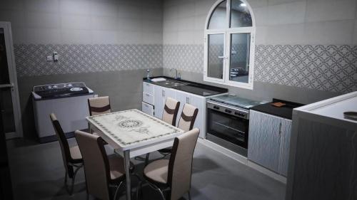 a kitchen with a table and a table and chairs at Al Dhabi Farm with Meeting Hall in Şufayrī