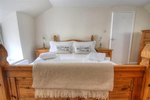 een slaapkamer met een groot bed met 2 kussens bij Foxley Cottage in Charmouth
