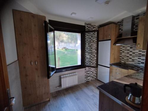 a kitchen with a large window in a room at Granja Las Callejuelas in Casla