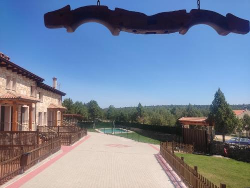 a gate with a tennis court in the distance at Granja Las Callejuelas in Casla