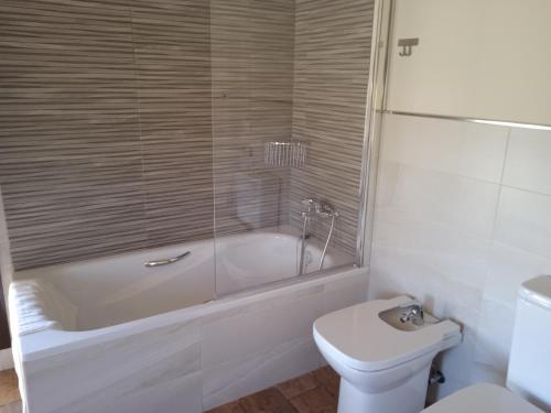 a bathroom with a tub and a toilet and a sink at Granja Las Callejuelas in Casla