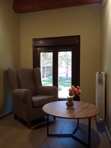 a living room with a chair and a coffee table at Granja Las Callejuelas in Casla