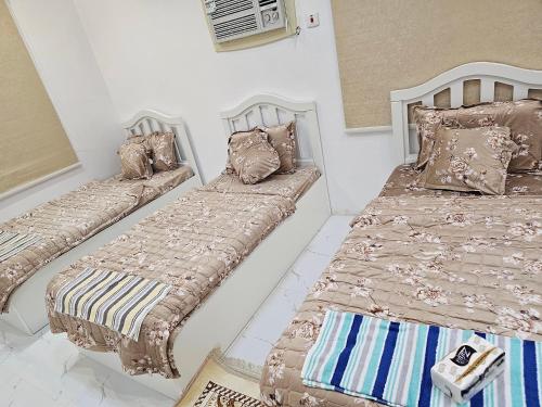 a bedroom with two beds with pillows on them at شقة مفرشة رقم 3 تبعد ٣ كم عن الحرم النبوي الشريف in Al Madinah