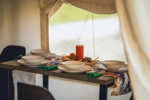 a table with bowls and plates on it at Glamping Pod Gwiazdami Pietrusza Wola in Pietrusza Wola