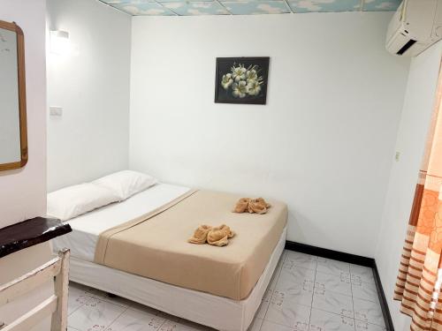 a bedroom with a bed with two towels on it at Bang sit Guest House in Phi Phi Don