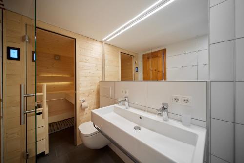 a bathroom with a white sink and a toilet at Alpenhaus Montafon by Pferd auf Wolke in Gargellen
