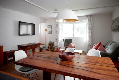een woonkamer met een houten tafel en een bank bij Alpenhaus Montafon in Gargellen
