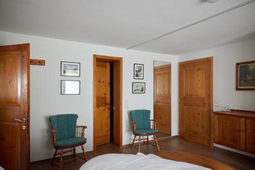 a bedroom with two chairs and a bed at Alpenhaus Montafon by Pferd auf Wolke in Gargellen