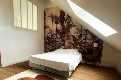 - une chambre avec un lit et une fresque murale de plantes dans l'établissement Le loft, à Saint-Nazaire