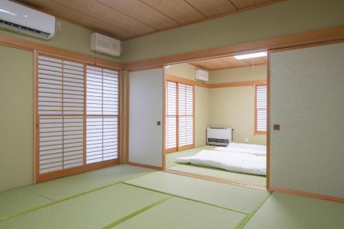 a bedroom with a bed in a room with windows at Chateau Ange UMAYA - Vacation STAY 68831v in Tsumagoi