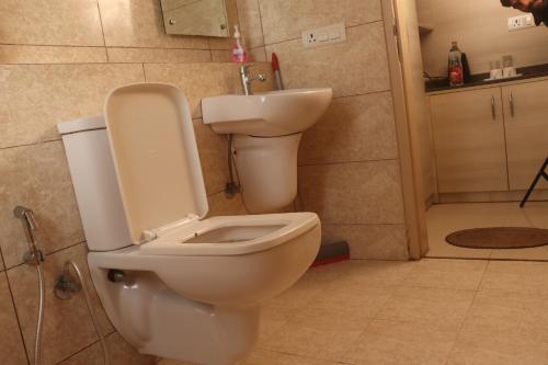 a bathroom with a toilet and a sink at Sridham Holiday Vrindavan in Vrindāvan