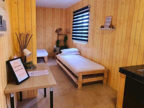 Cette chambre comprend un lit, un bureau et une table. dans l'établissement The Cabin by Grey - Vacation House and Events Place, à Kawit