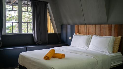 ein Schlafzimmer mit einem großen Bett mit zwei gelben Objekten darauf in der Unterkunft Kavy Boutique Hotel @ KBH in Brinchang
