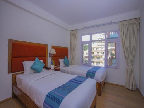 pokój hotelowy z 2 łóżkami i oknem w obiekcie Hotel Bodhiz TUSAL w Katmandu