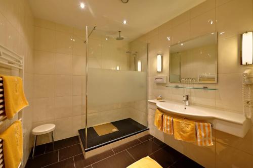a bathroom with a shower and a sink and a mirror at Alte Schmiede Hiltpolt in Seefeld in Tirol