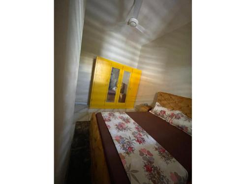 Habitación pequeña con cama y puerta amarilla en Residence in Tounkaranke, en Bamako