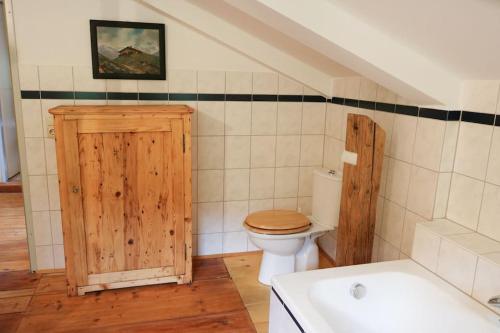 ein Badezimmer mit einem WC und einem Holzschrank in der Unterkunft Alte Mühle mit wunderbarem Bergblick in Ramsau bei Berchtesgaden