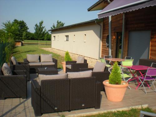 un patio con un montón de sillas y una mesa en Bio-Motel, en Saint-Vulbas