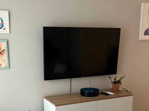 TV de pantalla plana colgada en la pared en Oasis Studio, en Bucarest