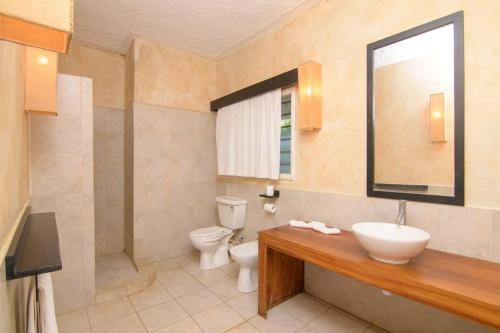 uma casa de banho com um lavatório, um WC e um espelho. em Apart No . 112 situated at Lawfords Beach Resort em Malindi