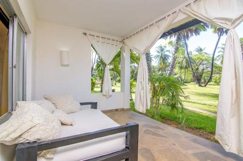 um quarto com uma cama e uma grande janela em Apart No . 112 situated at Lawfords Beach Resort em Malindi