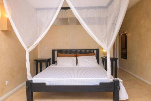 um quarto com uma cama e uma rede mosquiteira em Apart No . 112 situated at Lawfords Beach Resort em Malindi