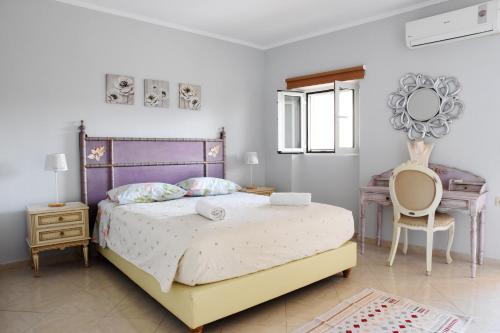 una camera con un grande letto e una scrivania di Villa Maxim in Corfu Town a Anemómylos