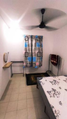 Alysha Homestay في كوالا ليبيس: غرفة نوم بسرير ومروحة سقف
