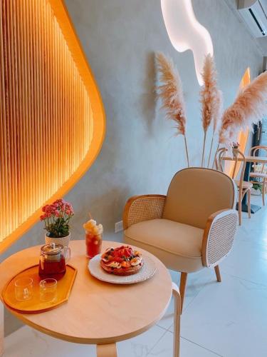 a table and a chair with a plate of food on it at 如沐咖啡旅宿 in Xingjian