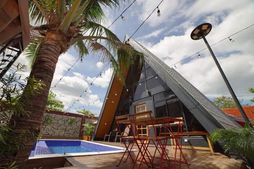 una casa con una piscina y una palmera en The Cabin by Grey - Vacation House and Events Place, en Kawit