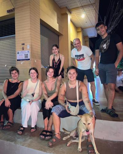 a group of people posing for a picture with a dog at Together Backpackers Hostel in Chiang Rai
