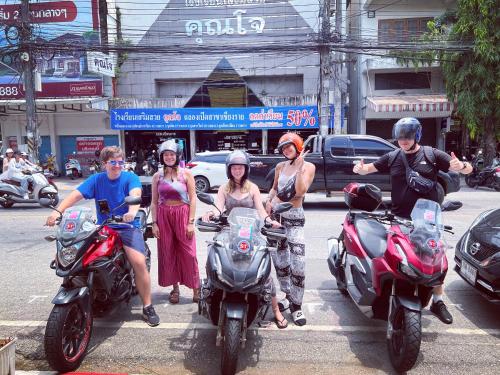 a group of people on motorcycles on a city street at Together Backpackers Hostel in Chiang Rai