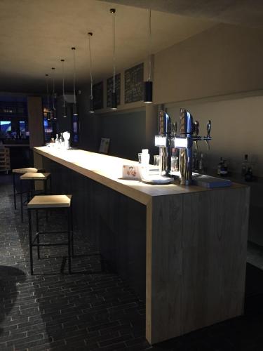 a bar in a restaurant with a counter with stools at BASE CAMP alpine apartments in Breuil-Cervinia