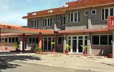 a large building with potted plants in front of it at Hotel Colombus in Aguada