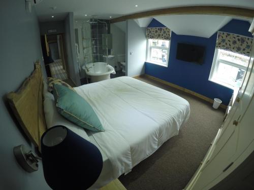a bedroom with a large bed and a bathroom at The Feathers in Ruthin