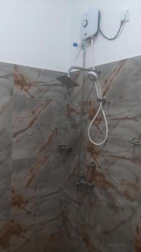 a shower in a bathroom with a stone wall at Alnaro Hotel & Resort in Moratuwa