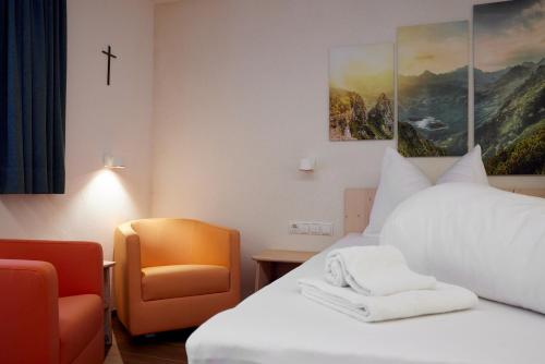 a hotel room with a bed and a chair at Alpenhaus Montafon by Pferd auf Wolke in Gargellen