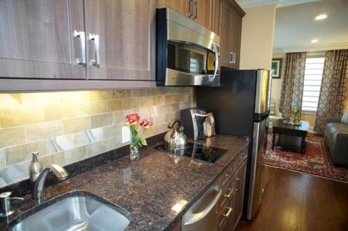 a kitchen with a sink and a refrigerator at Norwalk Inn & Conference Center in Norwalk