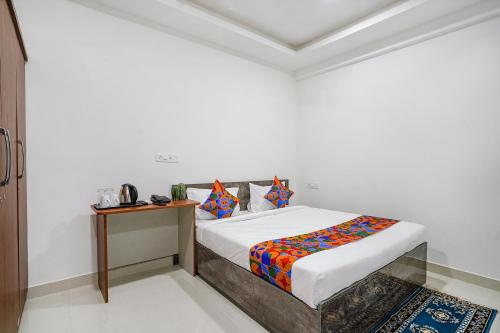 a white room with a bed and a table at FabHotel Rooms 27 in Hyderabad