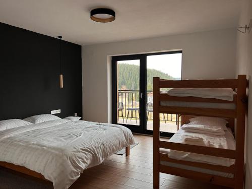 1 dormitorio con 2 literas y balcón en Cabana NORD, en Ciban